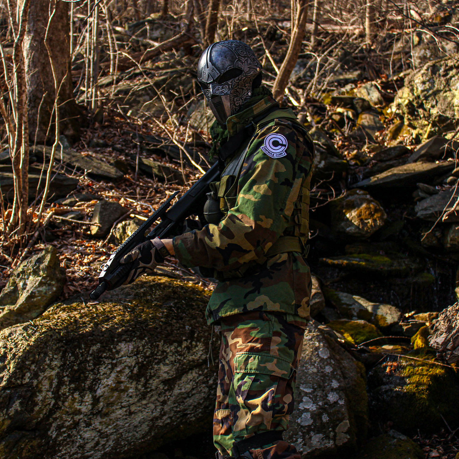 masked miltary mercenary holding a rifle in a forest